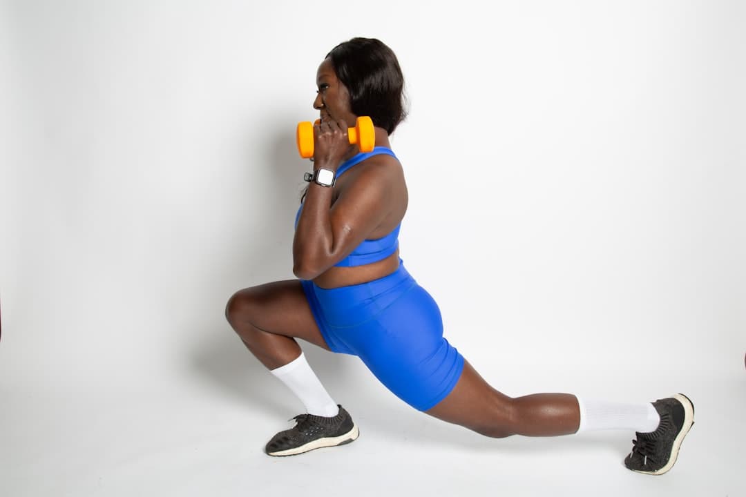 Black woman working out with dumbbells showing strength