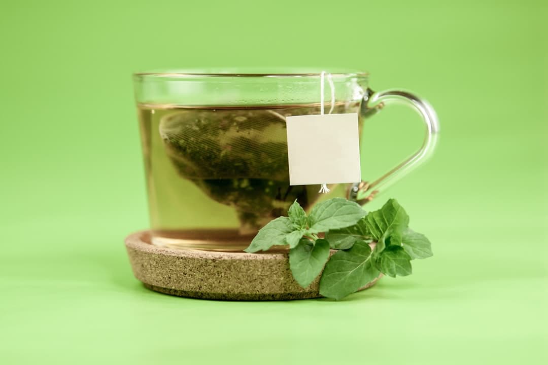 Herbal tea in a clear glass mug with fresh mint leaves